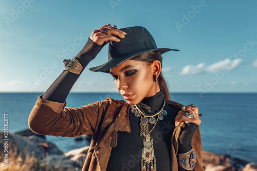 beautiful young fashionable woman portrait wearing hat at sunset