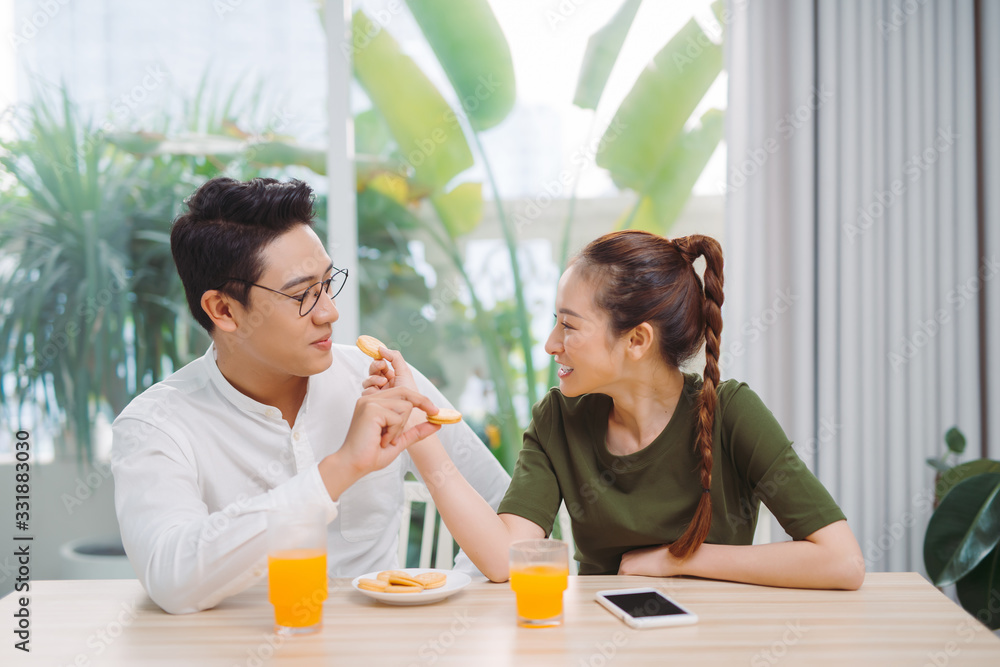 Young couple having fun while having breakfast feeding each other Young couple having fun while having breakfast feeding each other