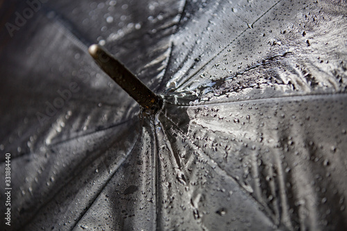 Wet textured surface of a black umbrella with drops of water after rain photo