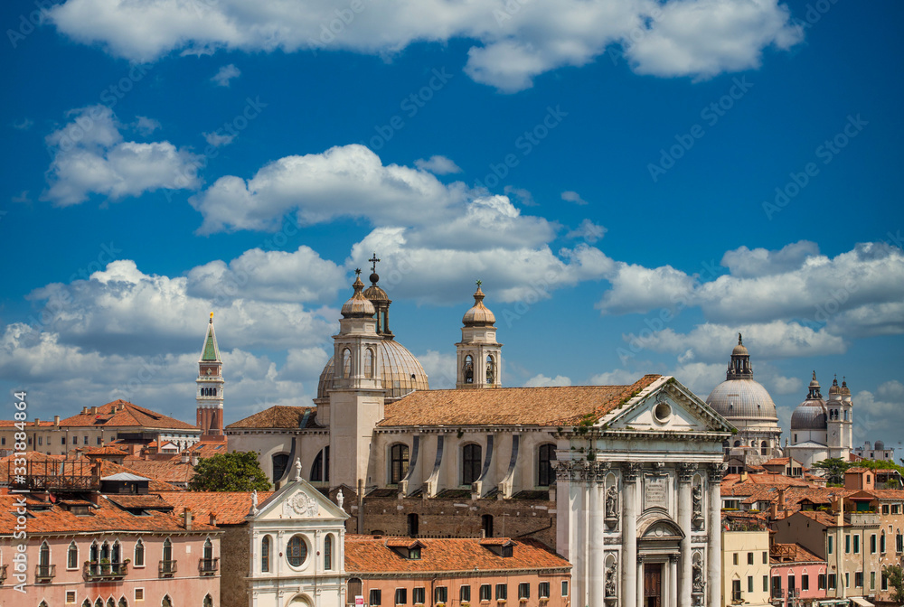 Red tile roofs and church domes under sky in Venice, Italy