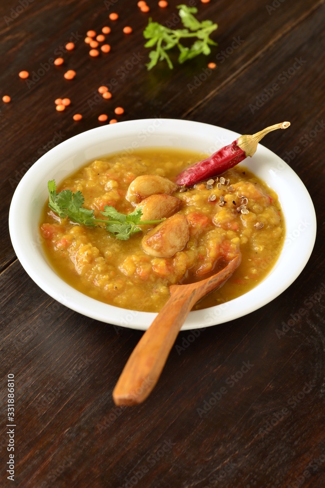 Dal, red lentil soup with turmeric, garlic, chili and cilantro. Indian food, vertical Dal, red lentil soup with turmeric, garlic, chili and cilantro. Indian food, vertical