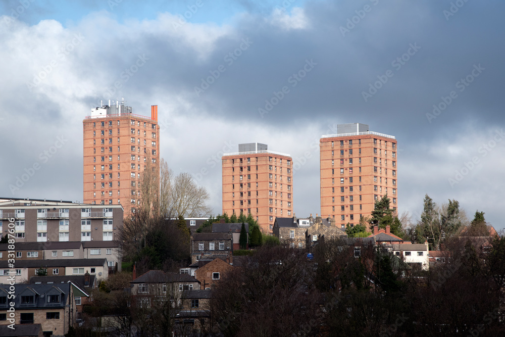 Three orange buildings against dramatic sky