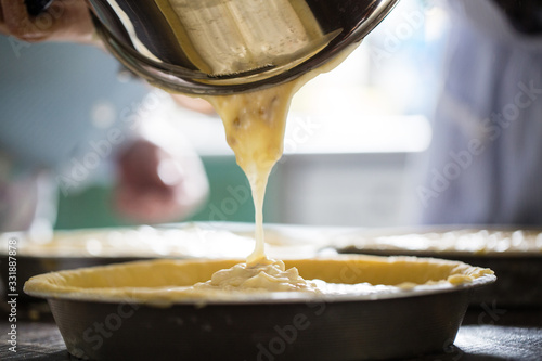 Preparation of Easter cake, also called Pastiera Napoli, typical homemade dessert, with eggs, flour, sugar and vanilla, wheat and colored sugared almonds photo