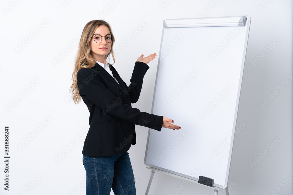 Young woman over isolated white background giving a presentation on white board Young woman over isolated white background giving a presentation on white board