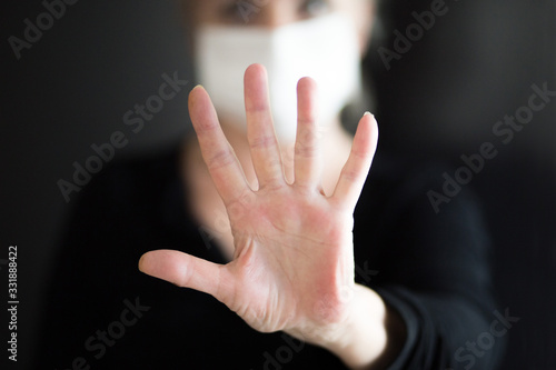 Senior woman wearing mask, shows clean hands and show stop hands. Selective focus. © Alexandra