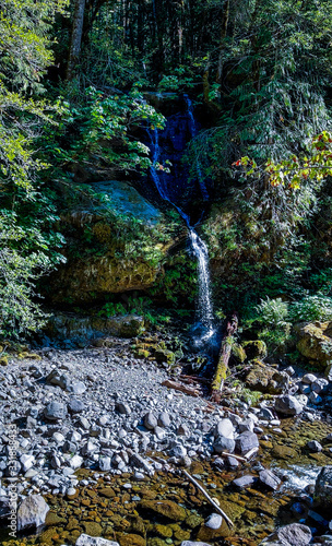 Flowing Steep Creek Falls in the mountains of Skamania County thru the boulders and vegetation in Washington State