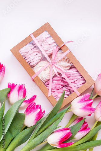 spring pink zephyrs with tulips on white background. concept zephyr flatlay with pink tulips