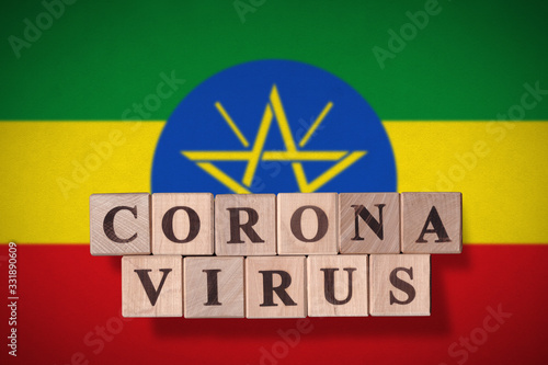 Flag of Ethiopia with wooden cubes spelling coronavirus on it. 2019 - 2020 Novel Coronavirus (2019-nCoV) concept, for an outbreak occurs in Ethiopia. photo