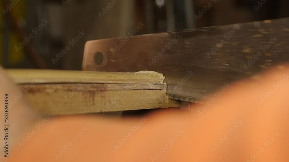 carpenter cutting wood with hand saw macro carpenter cutting wood with hand saw macro