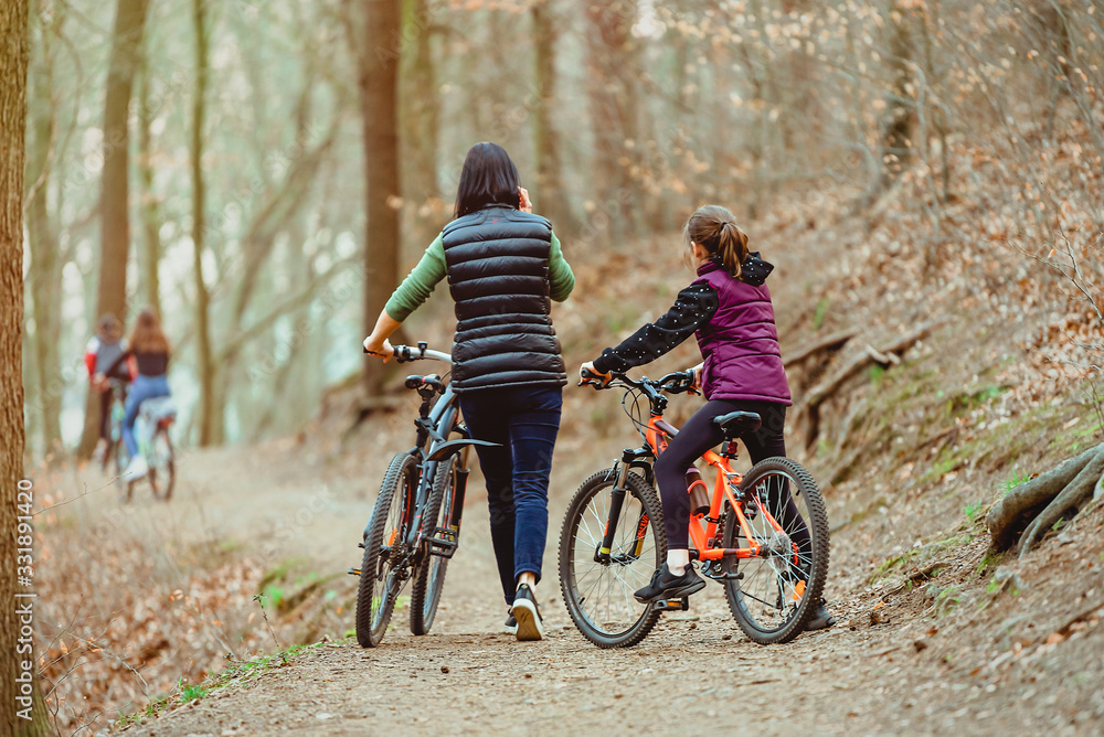 Naklejka premium Family holiday. Bicycle walk in the forest with children