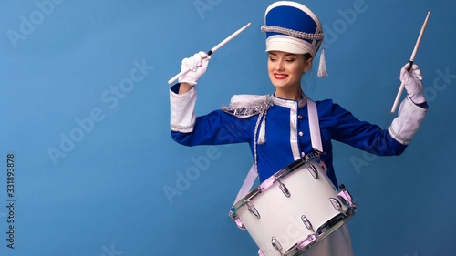 Foto drummer in a blue uniform drums on a drum, show program and celebration