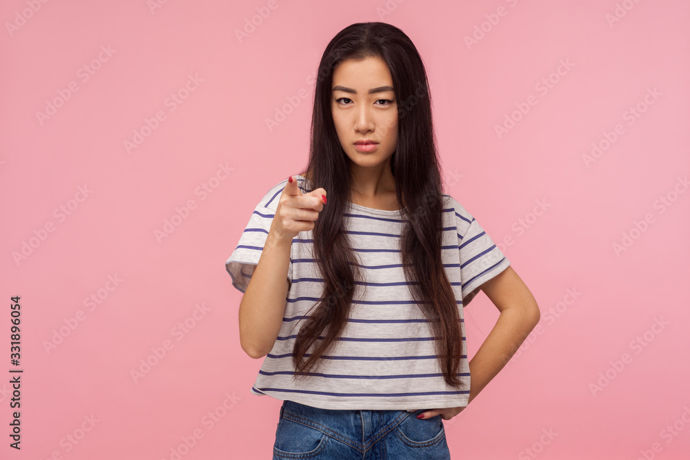 I told you! Portrait of angry girl with long hair in striped t-shirt pointing finger at camera and looking with dissatisfied suspicious expression, warning about troubles. indoor studio shot isolated I told you! Portrait of angry girl with long hair in striped t-shirt pointing finger at camera and looking with dissatisfied suspicious expression, warning about troubles. indoor studio shot isolated