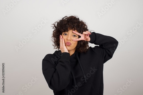 Leisure lifestyle people person celebrate flirt coquettish concept. Beautiful pretty cheerful gorgeous blonde showing making v-sign near eyes wearing casual clothes standing against gray wall.