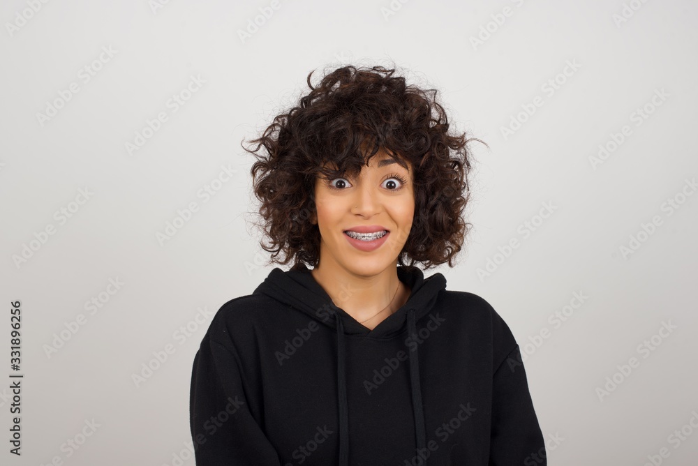 Young beautiful girl with an afro hairstyle having broad white smile being excited to meet Friends and go out to have a good day. Young beautiful girl with an afro hairstyle having broad white smile being excited to meet Friends and go out to have a good day.