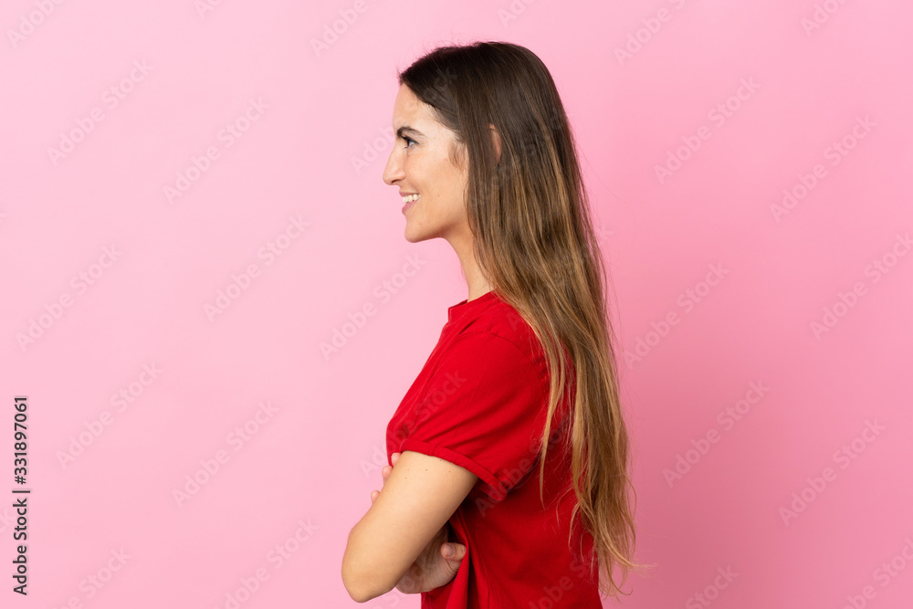 Young caucasian woman isolated on pink background in lateral position Young caucasian woman isolated on pink background in lateral position