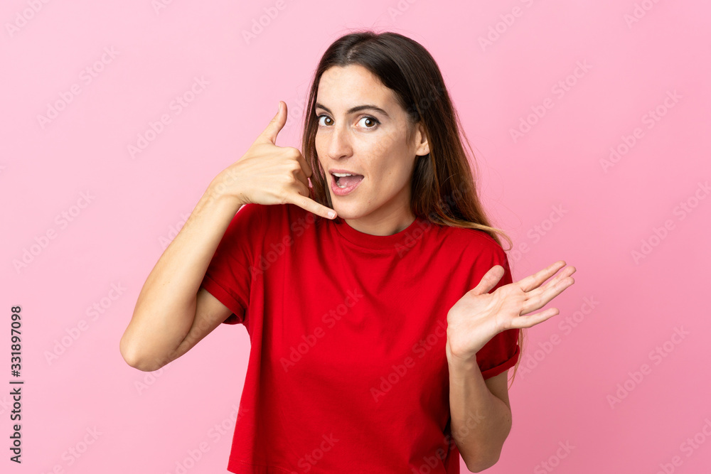 Young caucasian woman isolated on pink background making phone gesture and doubting Young caucasian woman isolated on pink background making phone gesture and doubting