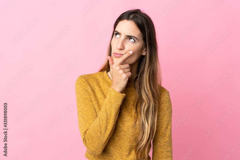 Young caucasian woman isolated on pink background having doubts Young caucasian woman isolated on pink background having doubts
