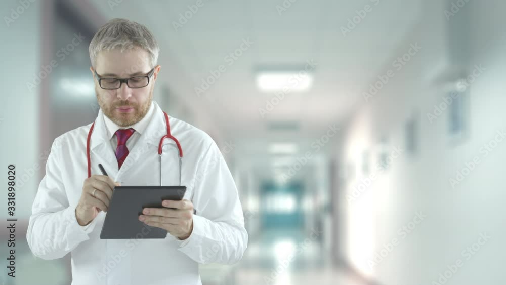 Doctor fills out checklist in the tablet. Shot on Red camera Doctor fills out checklist in the tablet. Shot on Red camera