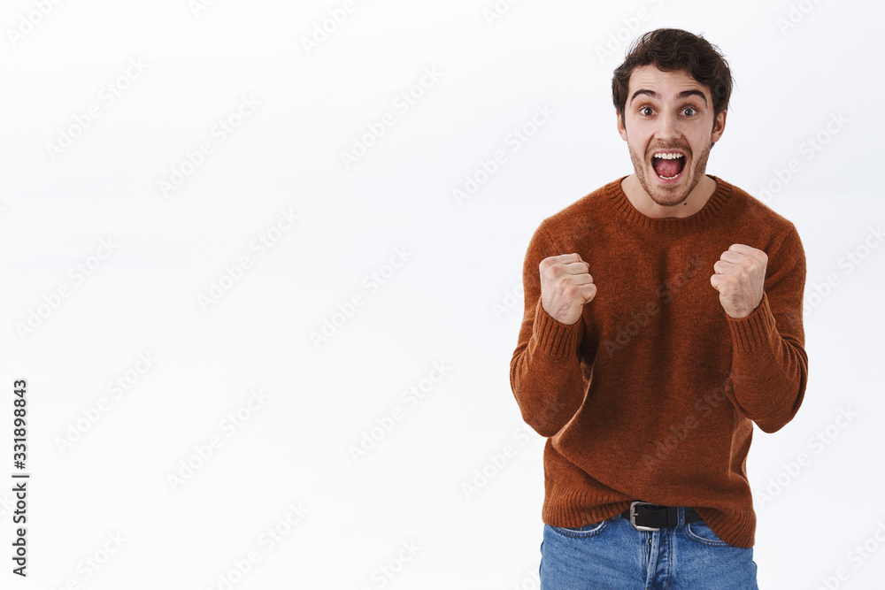 Prize, lottery and win concept. Excited happy young man scream yes from success, achieve goal, fist pump and looking camera cheerful, winning competition, watching awesome match, white background Prize, lottery and win concept. Excited happy young man scream yes from success, achieve goal, fist pump and looking camera cheerful, winning competition, watching awesome match, white background