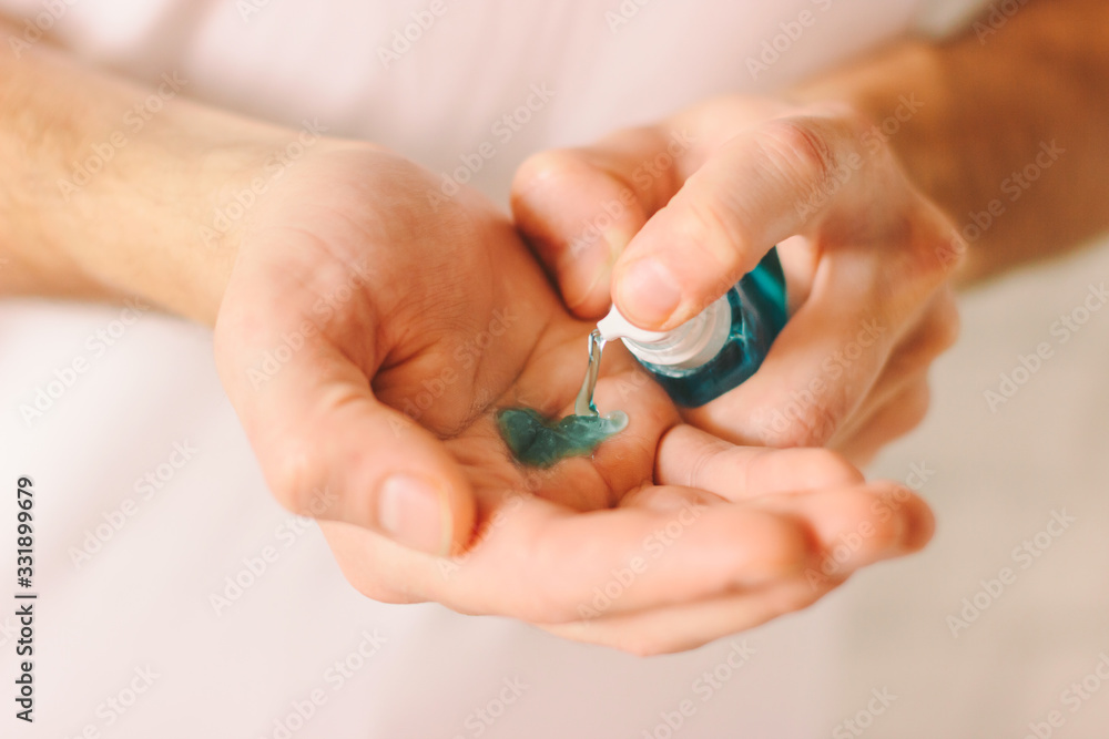 Closeup of man hands using antibacterial gel as preventive measure against contagious disease. Doctor applying sanitizer on palm for protection against coronavirus COVID-19, nCov-19. Safety hygiene