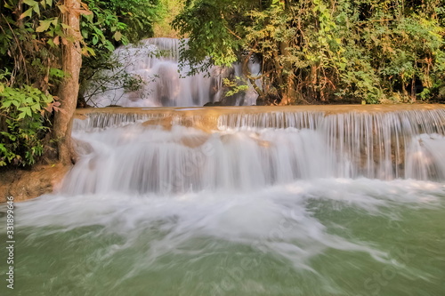 Fototapeta Naklejka Na Ścianę i Meble -  view of white silky water flowing around with green forest background, Huay Mae Khamin Waterfall floor 3th (Wang Nar Pha) Kanchanaburi, west of Thailand.