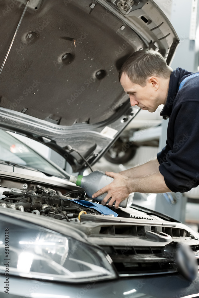 Hand mechanic in repairing car,Change the Oil.Car maintenance, concept. Middle shoot Hand mechanic in repairing car,Change the Oil.Car maintenance, concept. Middle shoot