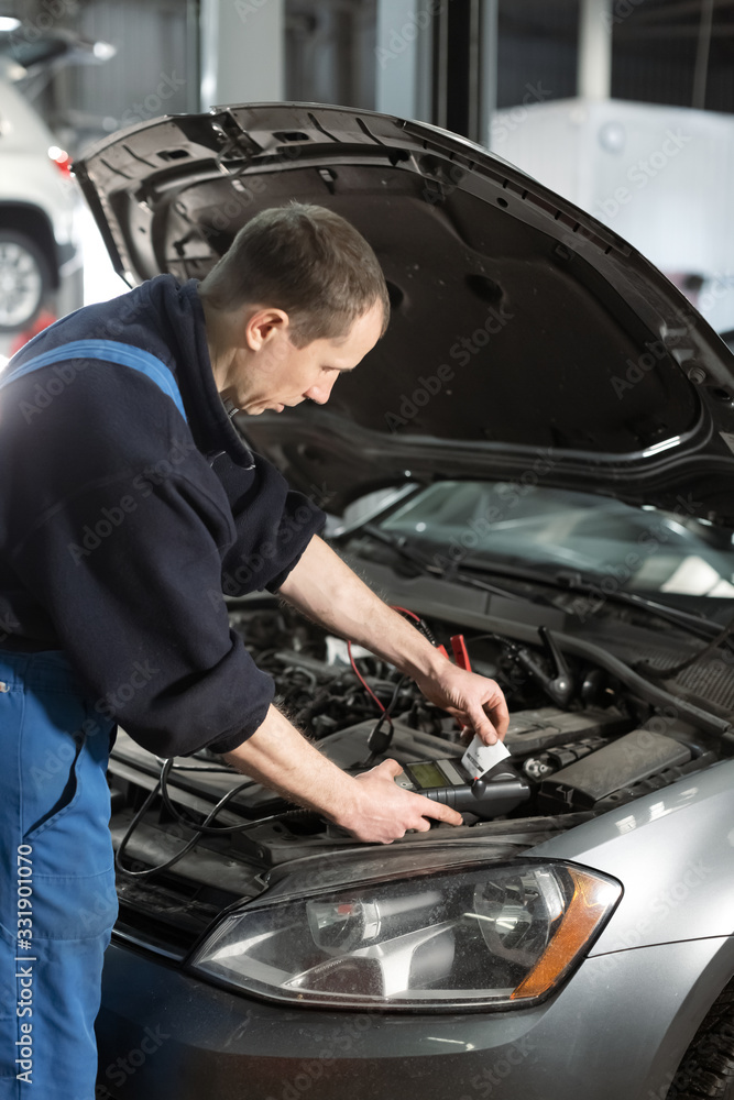 A team of technicians working on auto mechanics for car repair and maintenance work, car repair workers with battery inspections. A team of technicians working on auto mechanics for car repair and maintenance work, car repair workers with battery inspections.