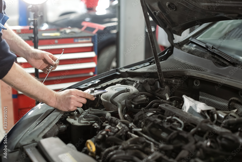 Hand of Mechanic technician service check antifreeze coolant fluid in garage Hand of Mechanic technician service check antifreeze coolant fluid in garage