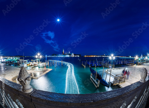 Night view of Gondolas near St Marks Square in Venice with the church of San Giorgio Maggiore on the background