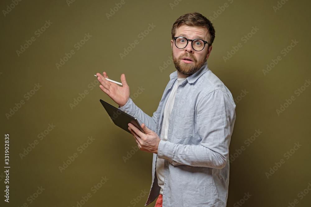 Discussion of the idea. Serious man with a tablet in one hand and a stylus in the other, talks about his project. Copy space. Discussion of the idea. Serious man with a tablet in one hand and a stylus in the other, talks about his project. Copy space.