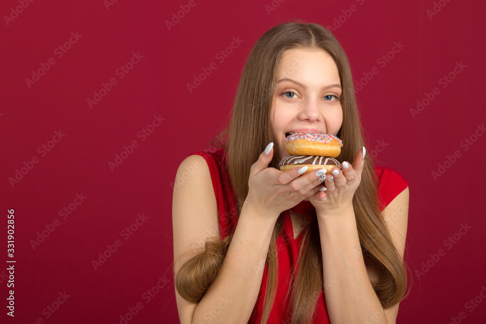 beautiful young woman with her hair on a red background with donuts beautiful young woman with her hair on a red background with donuts