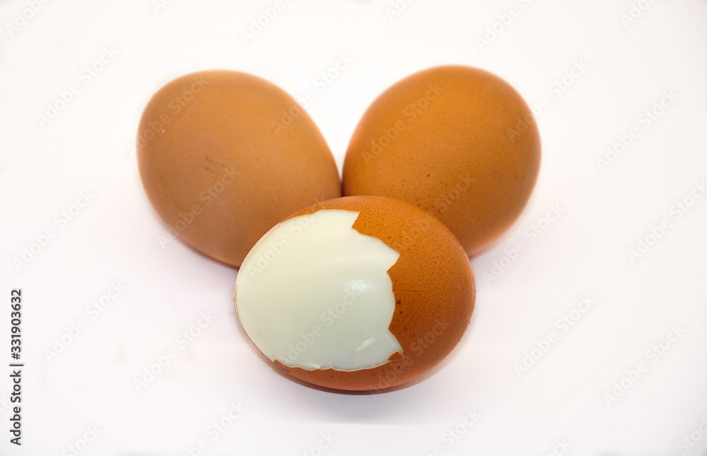 three eggs on white background. one peeled egg three eggs on white background. one peeled egg