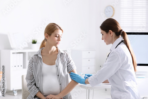 Doctor giving injection to pregnant woman in hospital. Vaccination concept