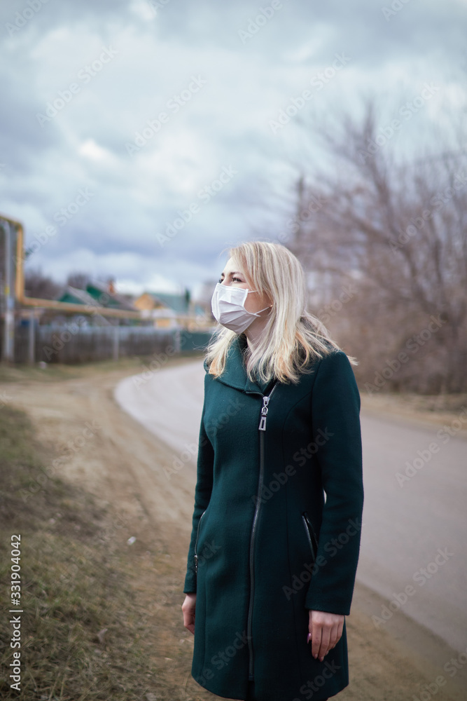 blonde girl in a medical mask on the street