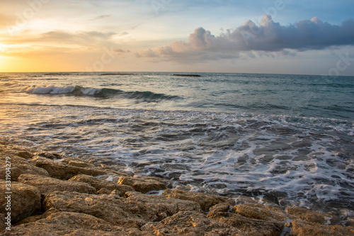 Sunshine from sundown on the stones of the seashore cloudscape during the summer time in Bali © Souvik