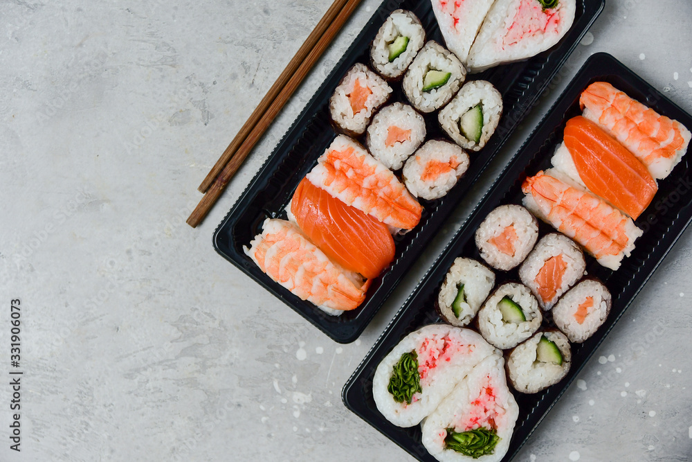 food delivery. set of sushi and rolls with salmon and shrimp. service food order online and home delivery during the COVID-19 coronavirus quarantine . concept layout 2 for the price of 1.