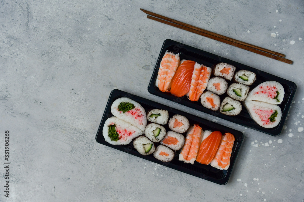 food delivery. set of sushi and rolls with salmon and shrimp. service food order online and home delivery during the COVID-19 coronavirus quarantine . concept layout 2 for the price of 1. food delivery. set of sushi and rolls with salmon and shrimp. service food order online and home delivery during the COVID-19 coronavirus quarantine . concept layout 2 for the price of 1.
