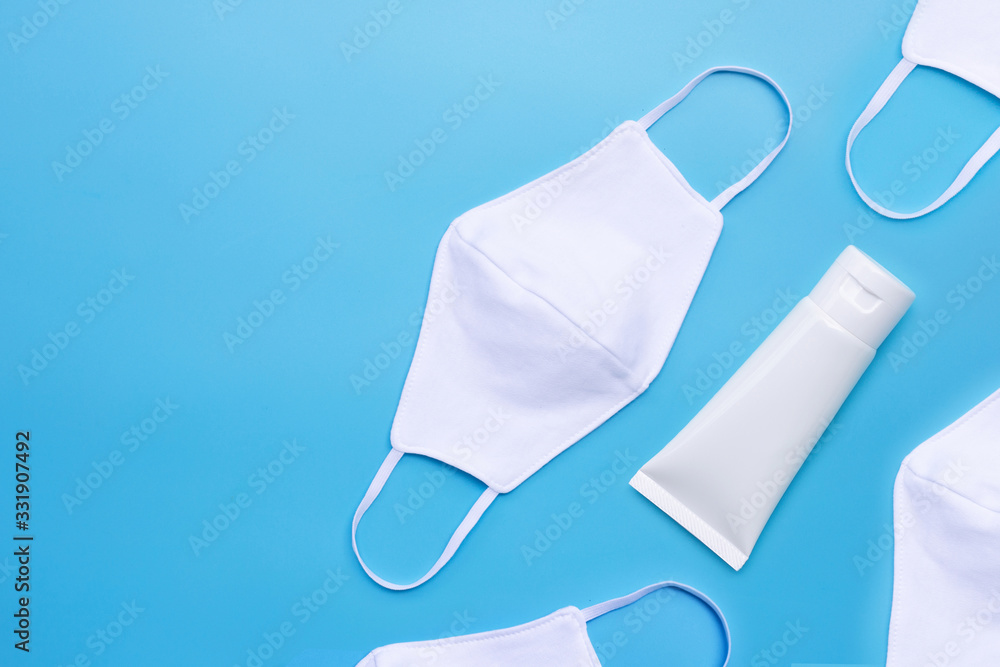 Masks and Alcohol hand sanitizer gel in white glossy plastic tube for hygiene corona virus (Covid-19) protection. Blue background Masks and Alcohol hand sanitizer gel in white glossy plastic tube for hygiene corona virus (Covid-19) protection. Blue background