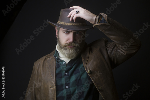 The hard look of a man from the Wild West. Brutal portrait of a cowboy man in a hat.