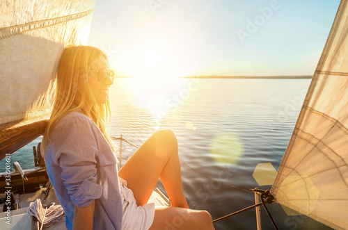 Young happy woman enjoying sunset from deck of sailing boat movi photo