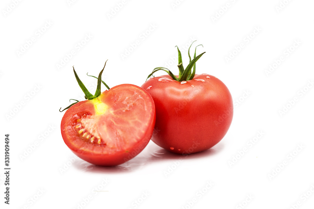 Ripe fresh organic tomato and half a tomato in dew drops isolated on a white background Ripe fresh organic tomato and half a tomato in dew drops isolated on a white background