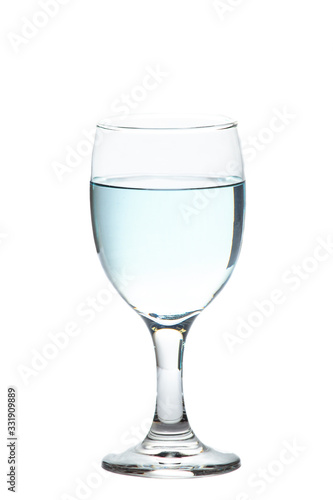 The water from the bottle is poured into a separate glass on a white background. Concept for health