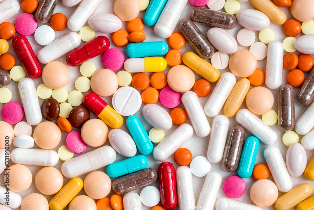 Multi-colored pills, tablets from the virus, flu on a light background. Protection against the viral pandemic of the coronavirus COVID-19. Multi-colored pills, tablets from the virus, flu on a light background. Protection against the viral pandemic of the coronavirus COVID-19.