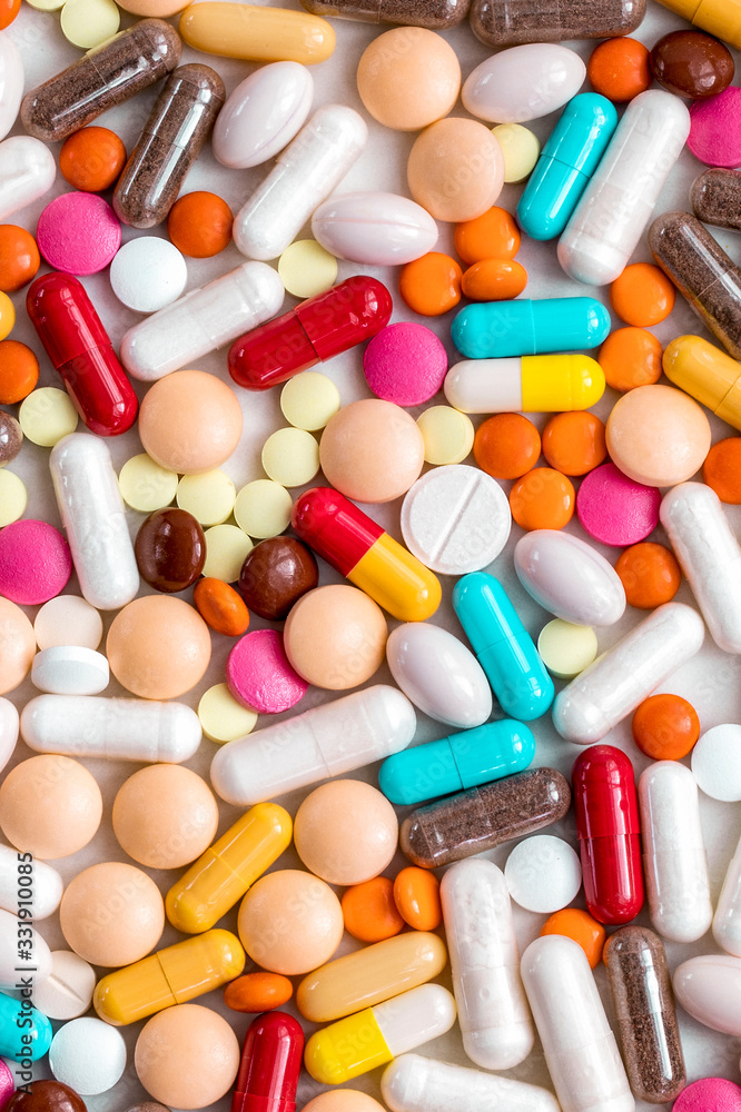Multi-colored pills, tablets from the virus, flu on a light background. Protection against the viral pandemic of the coronavirus COVID-19. Multi-colored pills, tablets from the virus, flu on a light background. Protection against the viral pandemic of the coronavirus COVID-19.