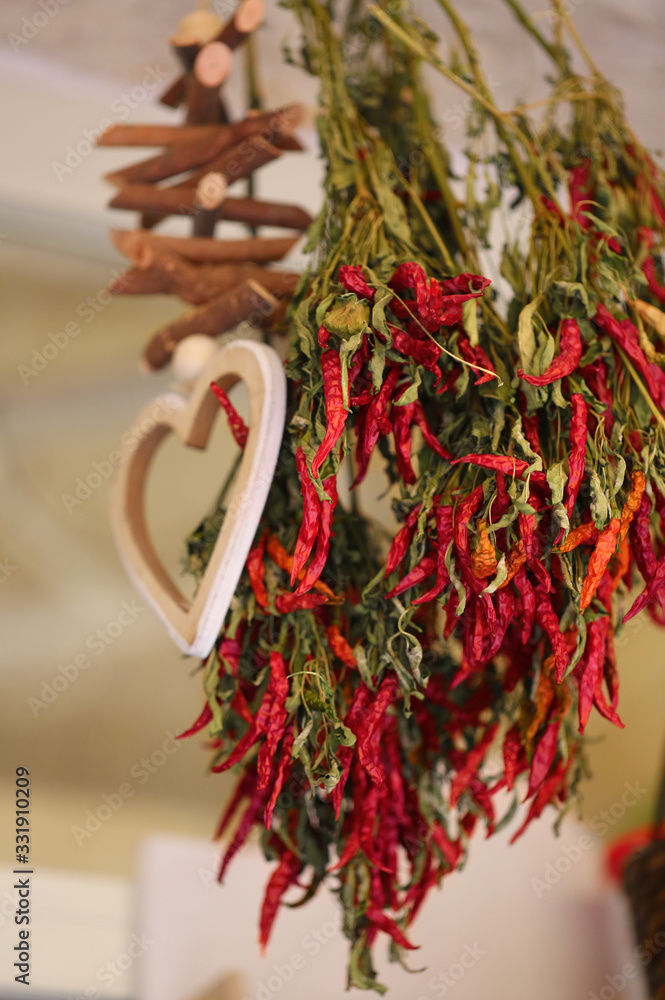Bunch of red lantern hot chilli peppers. A pile of red peppers are hanging on a market stand.