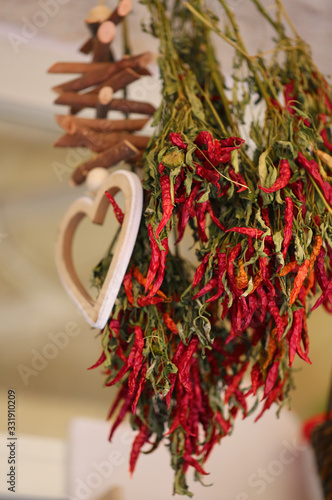 Obraz na płótnie Bunch of red lantern hot chilli peppers. A pile of red peppers are hanging on a market stand. w salonie