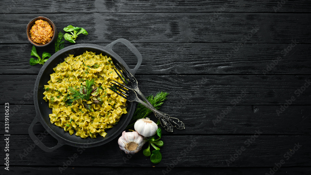 Pasta with pesto sauce, instant cooking in a frying pan. Top view. Free space for your text. Rustic style.