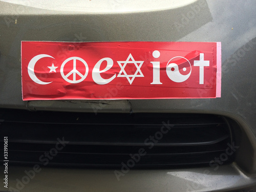 Red Coexist bumper sticker on car parked photo