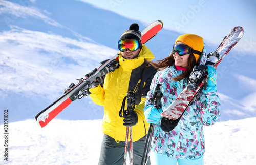 Young couple with skis on hill. Winter vacation