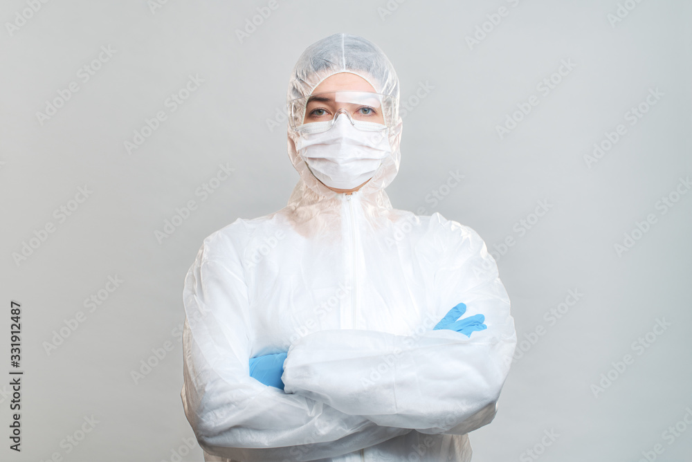 Man in protective suit, medical mask, goggles with arms crossed. Isolated in studio Man in protective suit, medical mask, goggles with arms crossed. Isolated in studio